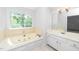 Bright bathroom with tub, a large window overlooking foliage, and a spacious vanity at 6000 Tenter Banks Sq, Raleigh, NC 27609