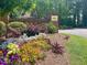 A decorative community entrance sign surrounded by vibrant flowers and lush landscaping, creating a welcoming atmosphere at 6000 Tenter Banks Sq, Raleigh, NC 27609