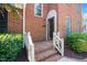 Inviting brick home entrance featuring a charming doorway, white railing, and well-maintained landscaping at 6000 Tenter Banks Sq, Raleigh, NC 27609