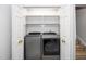 Laundry room with closet, washer and dryer, and wooden folding shelves at 6000 Tenter Banks Sq, Raleigh, NC 27609