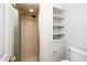 Shower with tile walls, adjustable shower head, and glass door, plus built-in wall shelves at 6000 Tenter Banks Sq, Raleigh, NC 27609