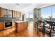 Bright kitchen with hardwood floors, stainless steel appliances, island, and dining table with glass doors to the terrace at 601 W Rosemary St # 905, Chapel Hill, NC 27516