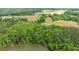 Expansive aerial view of a lake and property featuring lush forestry and cultivated fields at 675 Anderson Creek Rd, Henderson, NC 27537