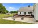 Large backyard featuring a deck, patio, storage shed, and lush green grass, ideal for outdoor activities at 675 Anderson Creek Rd, Henderson, NC 27537