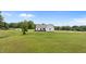 Green backyard showing the home's back elevation with a metal roof and expansive lawn, providing privacy at 675 Anderson Creek Rd, Henderson, NC 27537