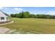 Large, well-maintained backyard extending from the side of the home to a line of trees at 675 Anderson Creek Rd, Henderson, NC 27537