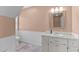 Cozy bathroom featuring a white sink vanity with a tiled countertop, a mirror, and wainscoting at 675 Anderson Creek Rd, Henderson, NC 27537