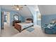 Well-lit bedroom with blue walls, wood furniture, a ceiling fan, and a comfortable armchair at 675 Anderson Creek Rd, Henderson, NC 27537