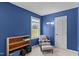 Bedroom featuring blue walls, a window, and a wooden bookshelf creating a serene space at 675 Anderson Creek Rd, Henderson, NC 27537