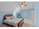 A cozy bedroom with light blue walls, a ceiling fan, and a large bed with patterned bedding at 675 Anderson Creek Rd, Henderson, NC 27537