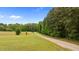 Long gravel driveway leading to the property surrounded by mature trees, offering a private entrance at 675 Anderson Creek Rd, Henderson, NC 27537