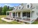 Charming home with a welcoming front porch, American flag, black shutters, and a well-manicured lawn at 675 Anderson Creek Rd, Henderson, NC 27537