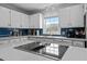 Well-lit kitchen with white countertops, tile backsplash, stainless steel appliances, and ample cabinet space at 675 Anderson Creek Rd, Henderson, NC 27537