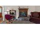 Comfortable living room featuring a stone fireplace, desk, and a cozy chair; perfect for relaxation at 675 Anderson Creek Rd, Henderson, NC 27537
