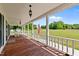 Covered front porch with wood flooring, decorative lighting, and view of the landscaped front yard at 675 Anderson Creek Rd, Henderson, NC 27537