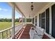 Charming front porch with wood flooring and white railing overlooking the expansive front yard, a great place to relax at 675 Anderson Creek Rd, Henderson, NC 27537