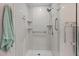 Modern walk-in shower featuring built in shelves, grab bars, and a clear glass door at 675 Anderson Creek Rd, Henderson, NC 27537