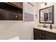 Comfortable bathroom with dark wood vanity, granite top, and framed mirror at 7015 Staghorn Ln, Raleigh, NC 27615