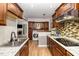 Open kitchen features granite counters, stainless appliances, wood cabinets and eat-in dining at 7015 Staghorn Ln, Raleigh, NC 27615