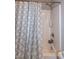 A well lit bathroom featuring a shower with patterned curtains at 71 Hunters Way, Angier, NC 27501
