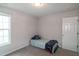 Sunlit bedroom featuring carpet, window and a cozy bed with striped blanket at 71 Hunters Way, Angier, NC 27501