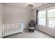 Cozy Bedroom featuring a crib, glider, and ample natural light from the large windows at 71 Hunters Way, Angier, NC 27501