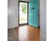 Bright entryway featuring hardwood floors and a vibrant turquoise front door, creating a welcoming ambiance at 71 Hunters Way, Angier, NC 27501