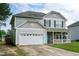 Gray two-story home with attached garage and well-maintained lawn under a partly cloudy sky at 71 Hunters Way, Angier, NC 27501