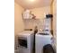 Bright laundry room with washer, dryer, and storage shelving at 71 Hunters Way, Angier, NC 27501