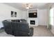 Comfortable living room featuring a fireplace, ceiling fan, and a plush leather sofa at 71 Hunters Way, Angier, NC 27501
