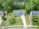 Two story home with a two car garage and large front yard landscaped with mature trees and asphalt driveway at 7209 Halstead Ln, Raleigh, NC 27613