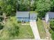 Aerial view of a blue two story home with a long driveway and a two car garage nestled among lush greenery at 7209 Halstead Ln, Raleigh, NC 27613
