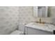 Stylish powder room with modern wallpaper, vanity, and gold fixtures at 7209 Halstead Ln, Raleigh, NC 27613