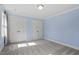 Bright bedroom with neutral carpet, light blue walls, a large closet, and natural light at 7209 Halstead Ln, Raleigh, NC 27613