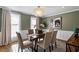 Bright dining room with a chandelier and dining table with seating, complemented by views from a large window at 7209 Halstead Ln, Raleigh, NC 27613