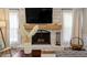 Bright living room features a whitewashed brick fireplace with hardwood floors, and comfortable seating at 7209 Halstead Ln, Raleigh, NC 27613