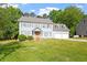 Inviting two-story home with a classic design, lush greenery, and a spacious front yard with shade trees at 7209 Halstead Ln, Raleigh, NC 27613