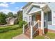 Lovely front porch with wooden door and brick steps on a two-story home with mature trees in the background at 7209 Halstead Ln, Raleigh, NC 27613
