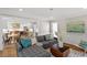 Bright, open-concept living room featuring hardwood floors, modern furniture, and an adjacent kitchen area at 7209 Halstead Ln, Raleigh, NC 27613