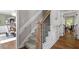 Elegant staircase with carpeted steps, wooden handrail, and black iron balusters leading to the upper level at 7209 Halstead Ln, Raleigh, NC 27613