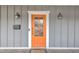 Close-up showcasing the vibrant orange front door of the home with modern accents and stylish lighting at 725 S State St, Raleigh, NC 27601