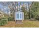Backyard shed with a blue door, surrounded by mature trees and shrubbery at 725 S State St, Raleigh, NC 27601
