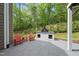 Outdoor patio with red Adirondack chairs and a fire pit overlooking the wooded backyard at 7517 Summer Pines Way, Wake Forest, NC 27587