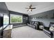 Spacious bonus room featuring a comfortable leather sofa, ceiling fan, and a large window offering plenty of natural light at 7517 Summer Pines Way, Wake Forest, NC 27587