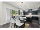 Modern dining area featuring dark cabinetry, stainless steel appliances, and a sliding glass door to a backyard at 7517 Summer Pines Way, Wake Forest, NC 27587