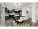 Modern dining area with dark cabinetry, stainless steel appliances, and a sliding glass door to a patio at 7517 Summer Pines Way, Wake Forest, NC 27587