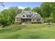Charming two-story home with lush lawn, mature trees, and a circular driveway leading to a garage at 7517 Summer Pines Way, Wake Forest, NC 27587