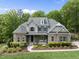 Beautiful two-story home with stone accents, a covered front porch, and manicured landscaping at 7517 Summer Pines Way, Wake Forest, NC 27587