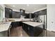 Spacious kitchen with dark cabinets, granite countertops, stainless steel appliances and large center island at 7517 Summer Pines Way, Wake Forest, NC 27587