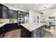 Stylish kitchen with a large center island, dark cabinetry, and modern stainless-steel appliances at 7517 Summer Pines Way, Wake Forest, NC 27587